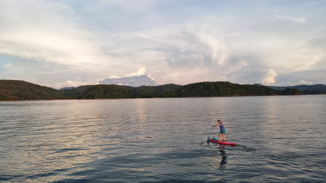 Stand up paddle boarding at Bigfin beach resort Sabah Borneo with view of Mount Kinabalu